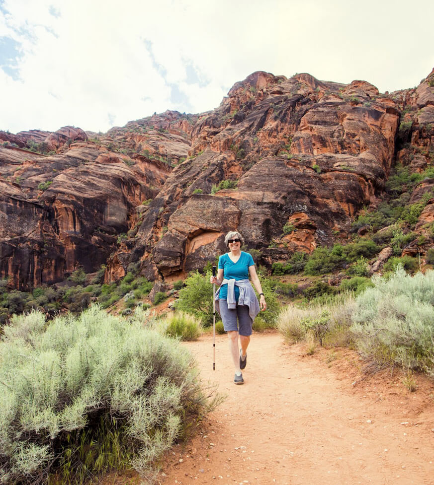 A Citrus Gardens lady resident carrying a backpack hikes at a mountain trail near Apache Junction, Arizona.