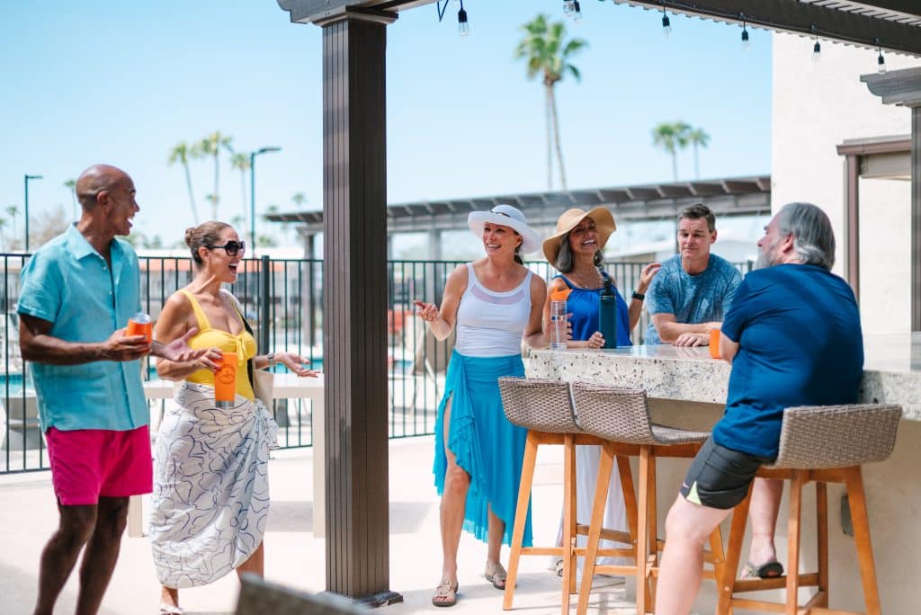 A group of couples bonding together in the pool area of manufactured homes.